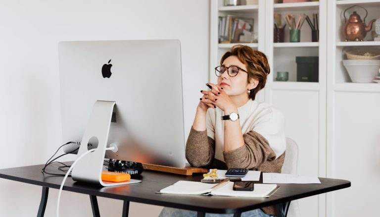 focused female employee reading information on computer in office