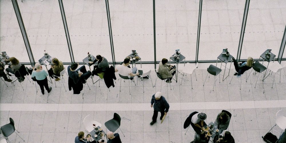 people sitting on chairs near tables during daytime