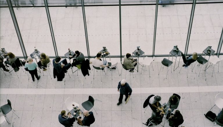 people sitting on chairs near tables during daytime