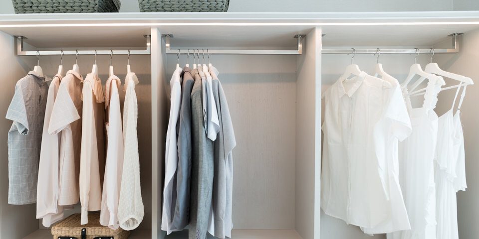 Modern interior wardrobe with shirt and dress in shelf.
