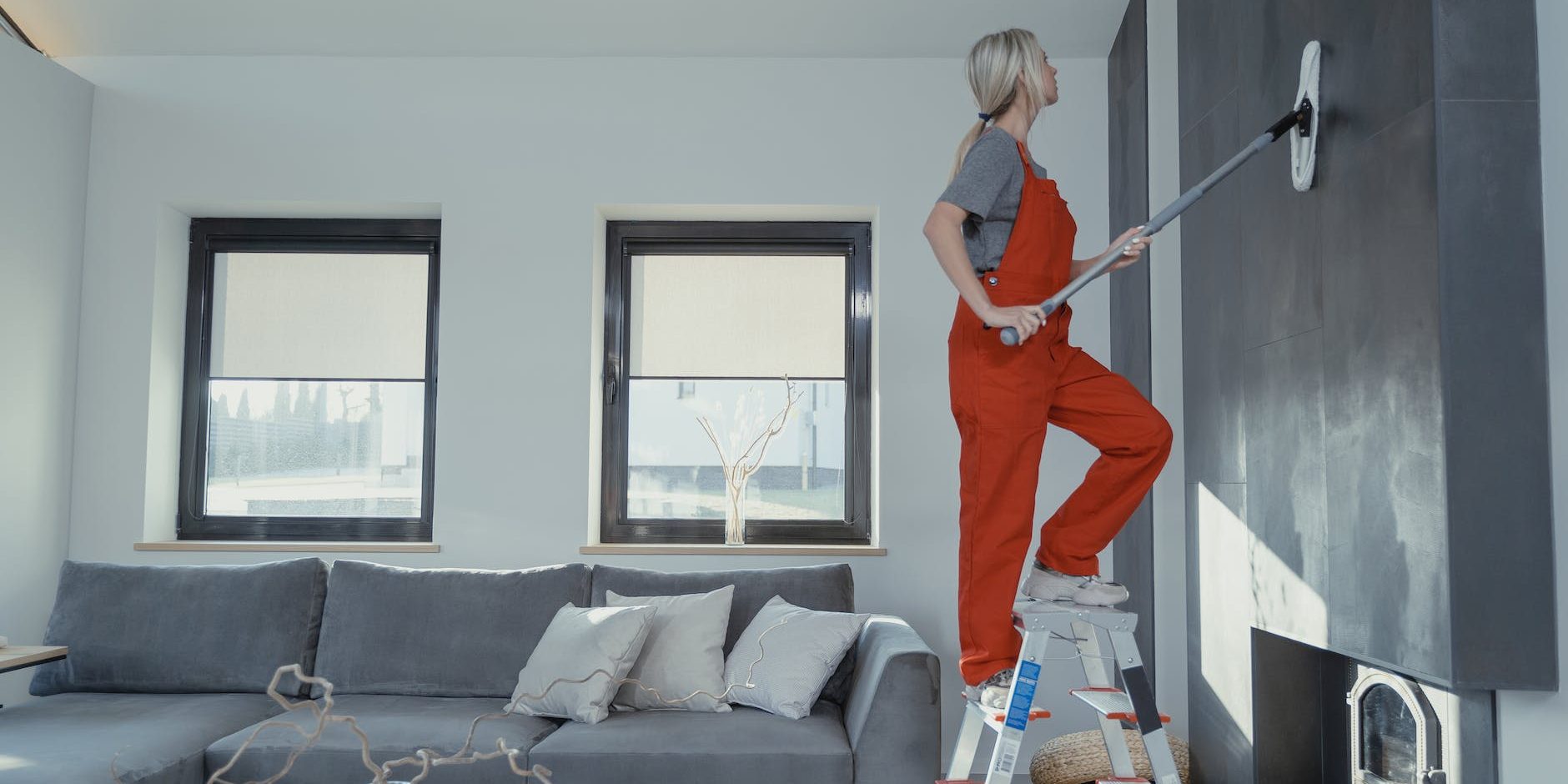 woman cleaning the wall with a mop