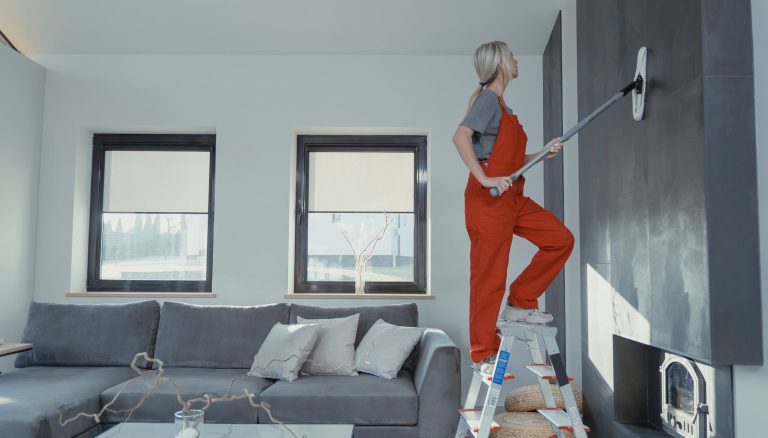 woman cleaning the wall with a mop