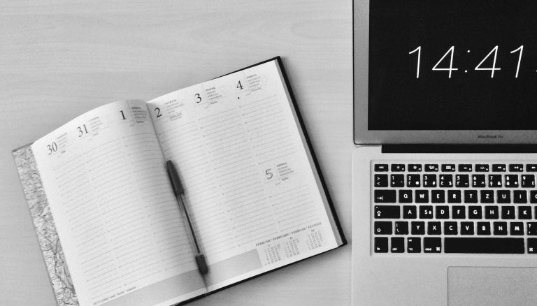 flat lay photography of unfold book beside macbook