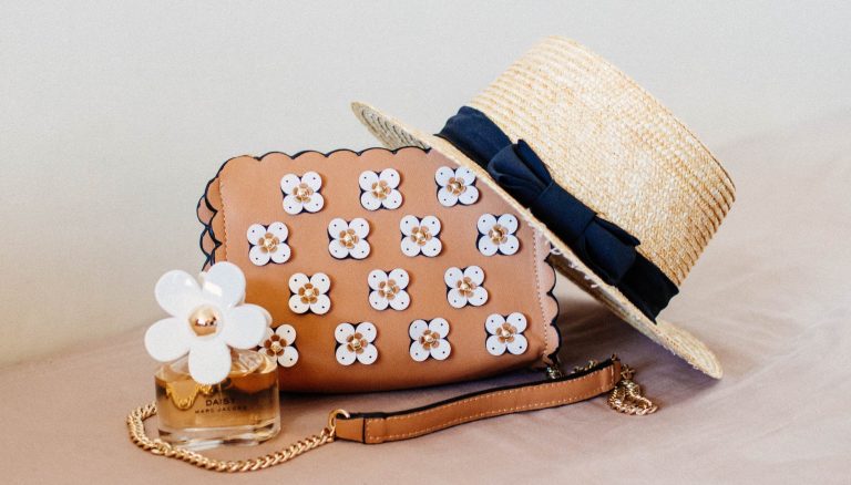 brown sun hat on brown and white floral sling bag