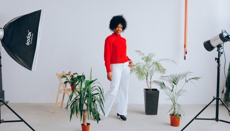 smiling ethnic woman having photo session with plants