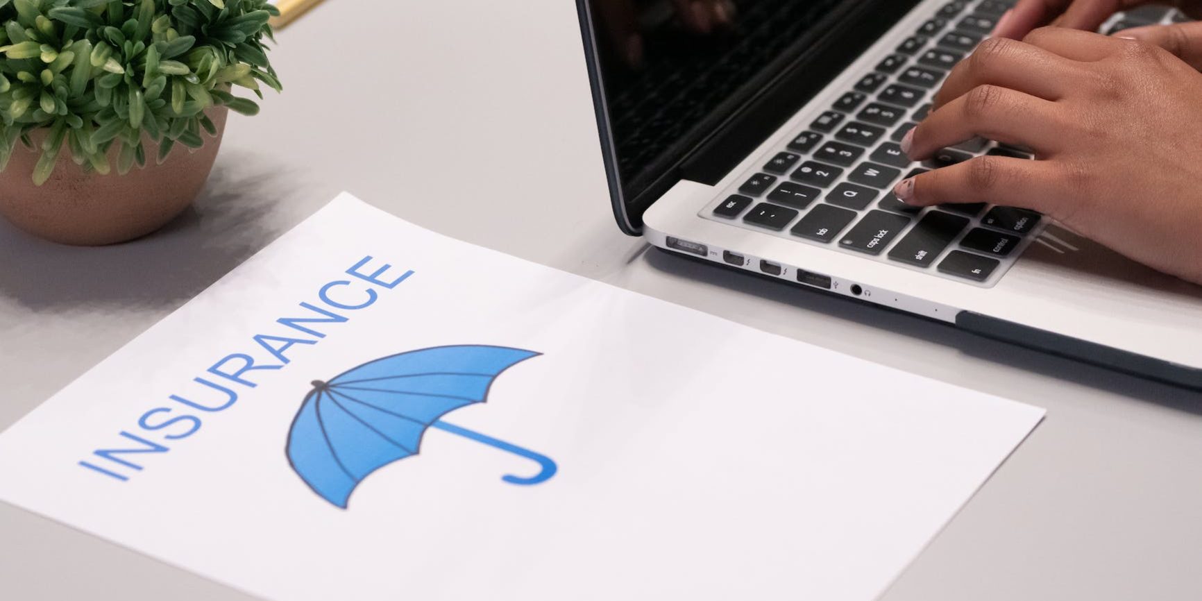 a paper beside a person typing on a laptop