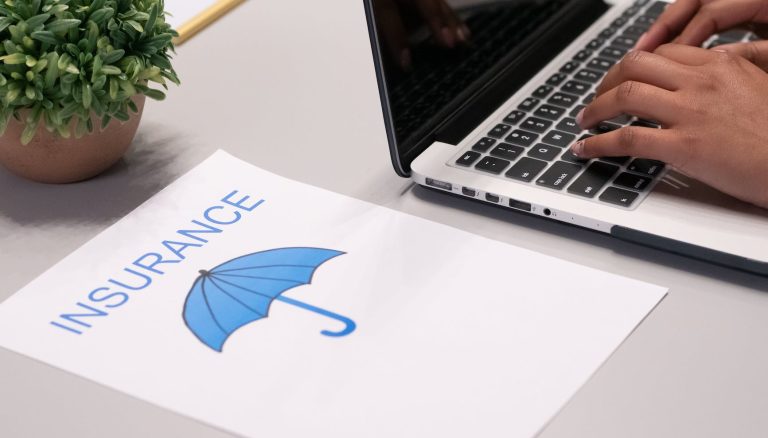 a paper beside a person typing on a laptop