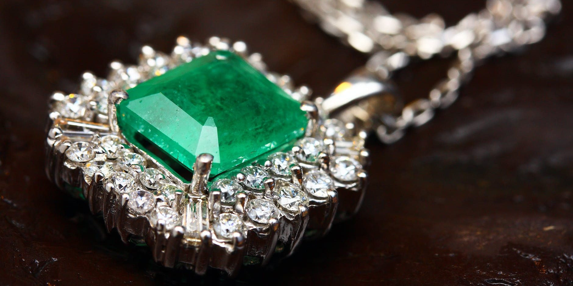 silver colored pendant with green gemstone