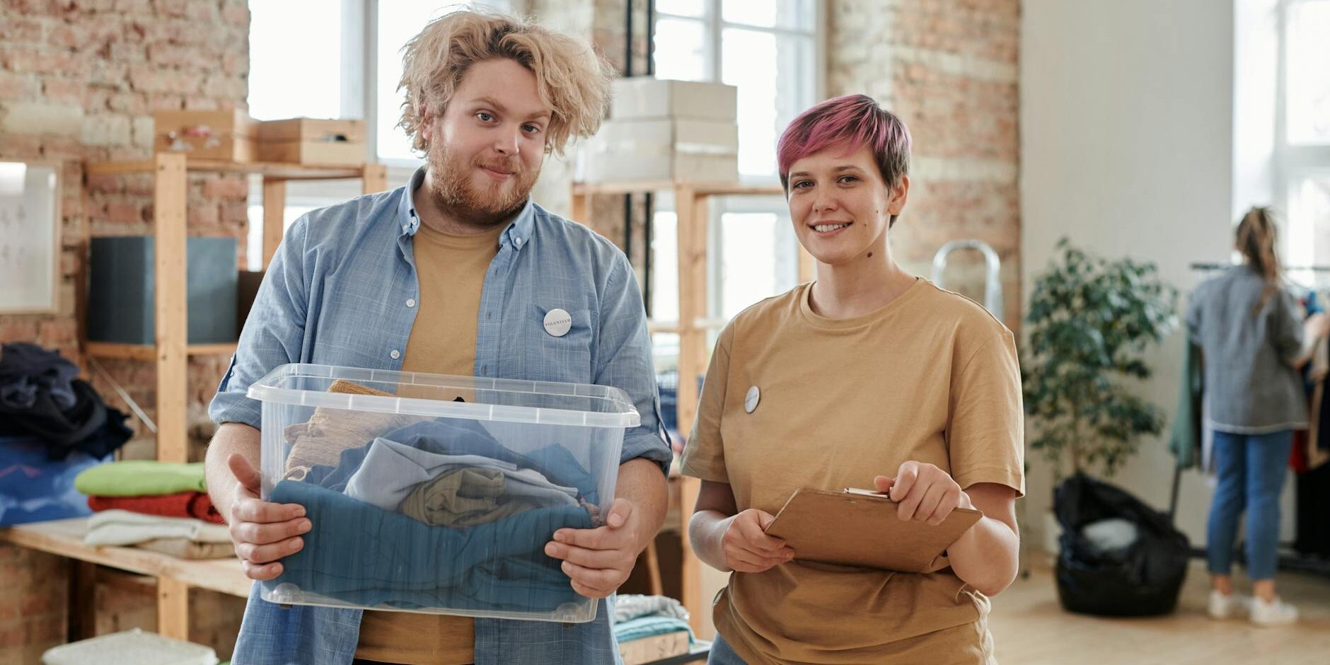 man and woman volunteers with box of clothes