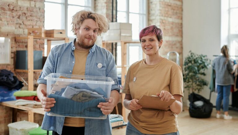 man and woman volunteers with box of clothes