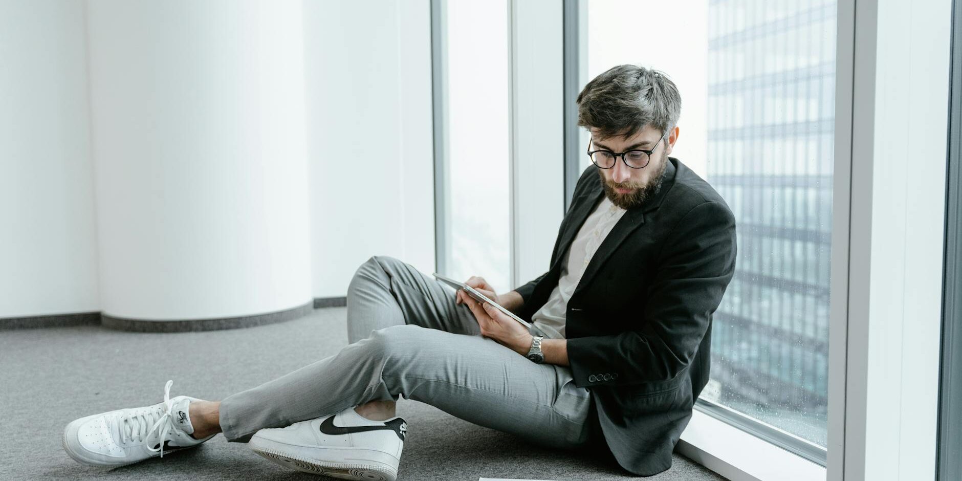 a man wearing black jacket looking at graphs on the floor