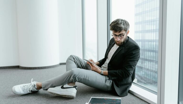 a man wearing black jacket looking at graphs on the floor