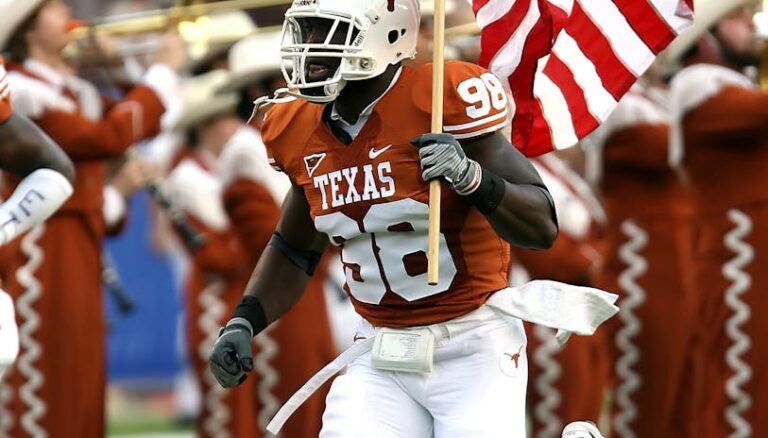 nfl player holding u s a flag on field