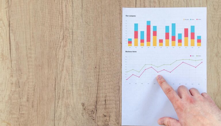 person pointing paper line graph