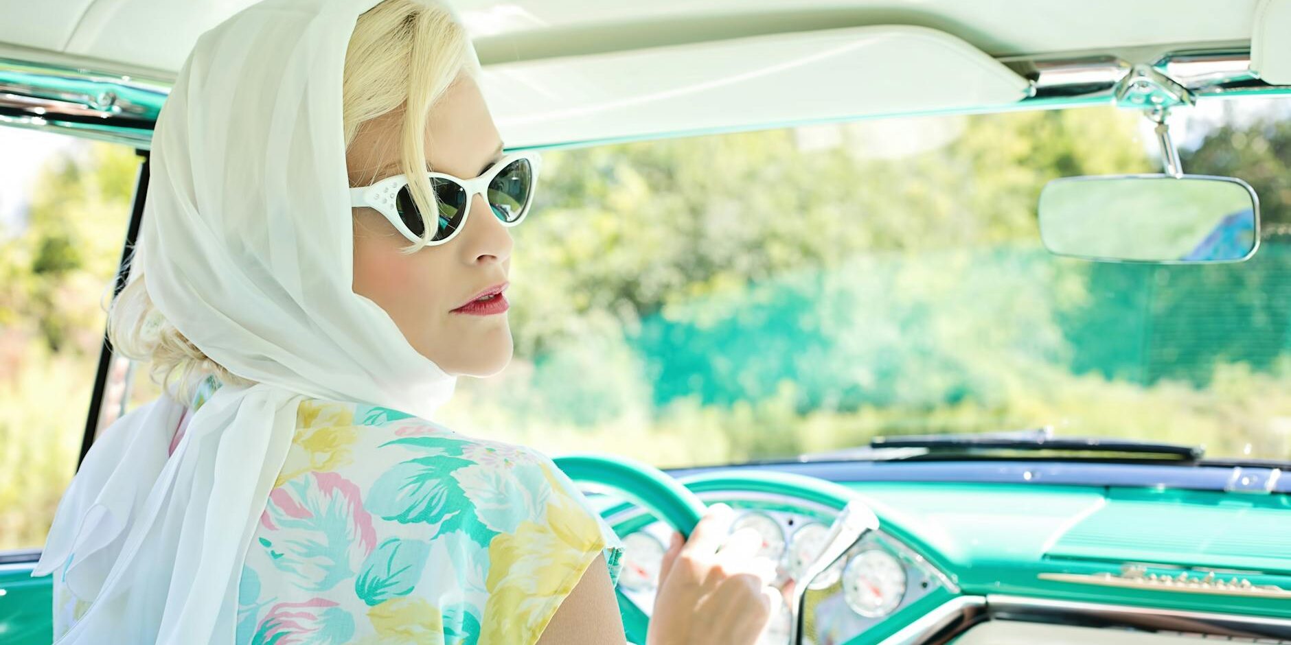 woman driving vintage car on road during daytime