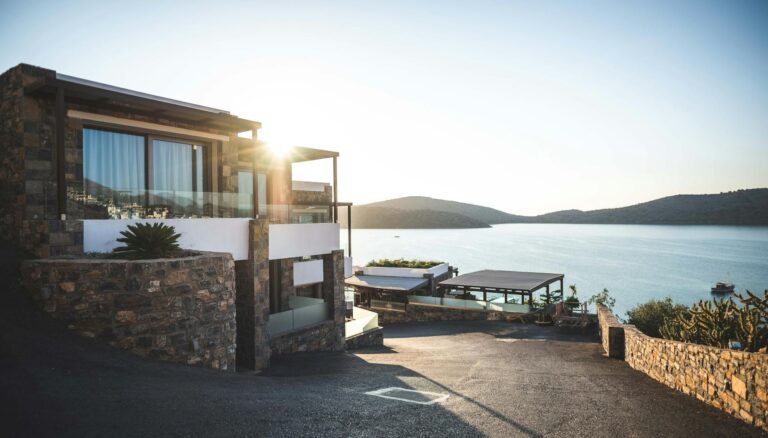 sun piercing of brown concrete house near sea