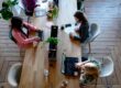three woman sitting on white chair in front of table