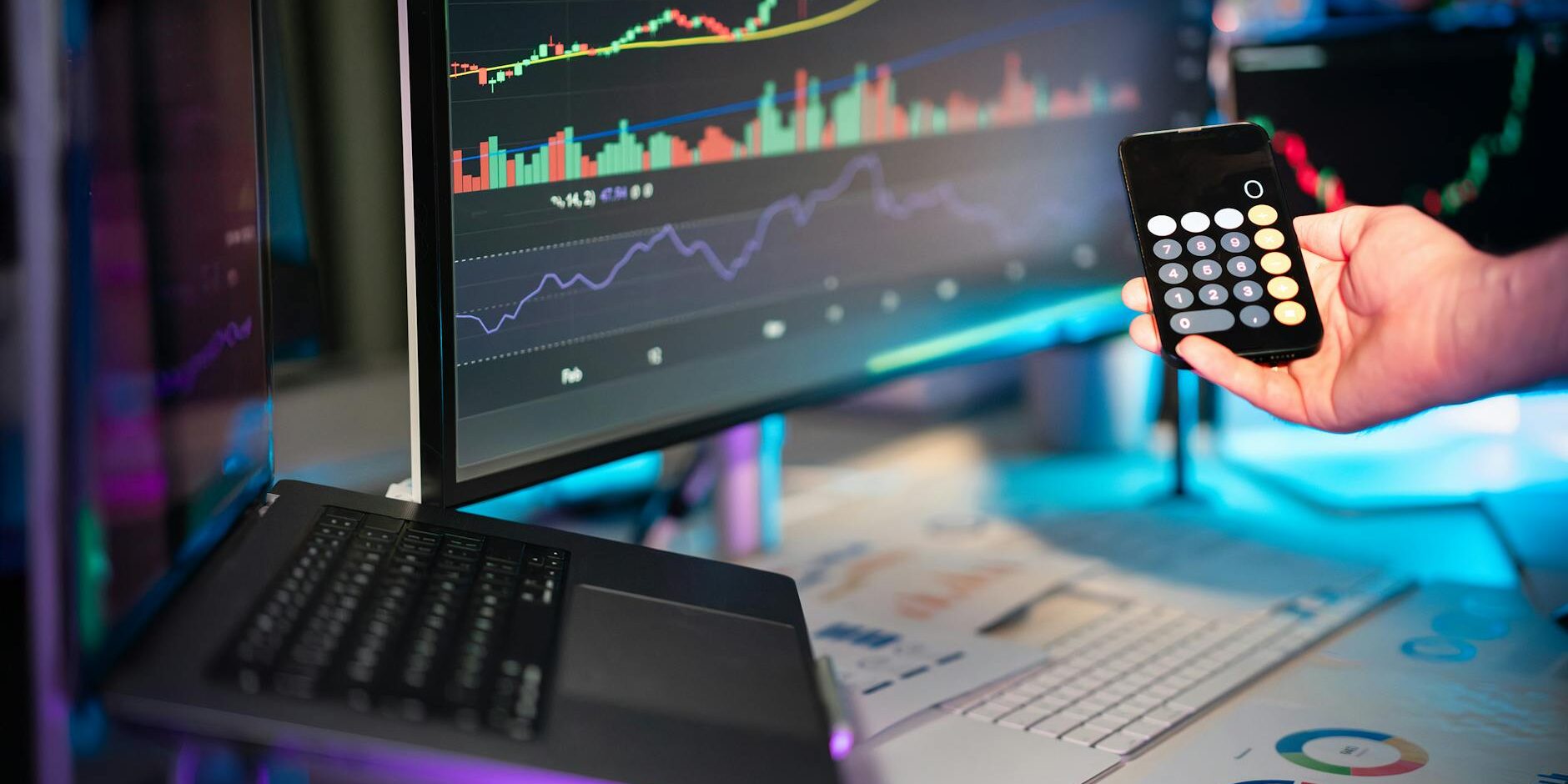 business economy hand holding smartphone calculator financial charts