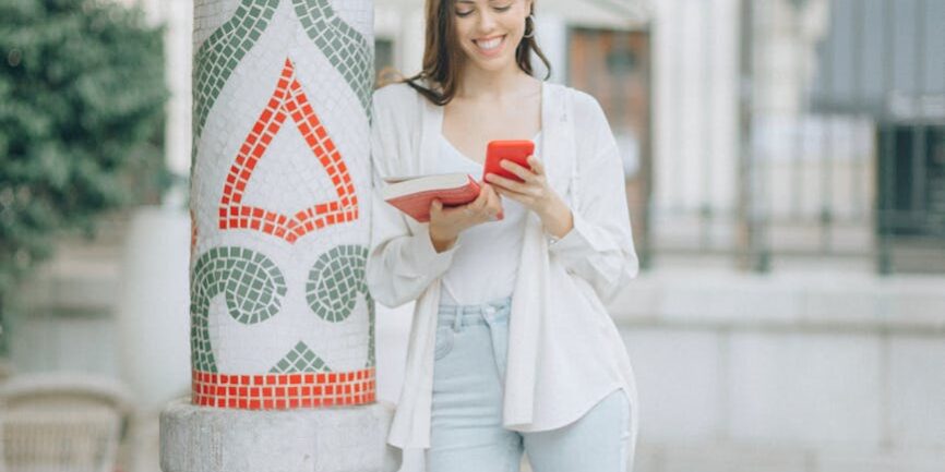 woman in white long sleeve shirt and white pants sitting on white and red floral concrete