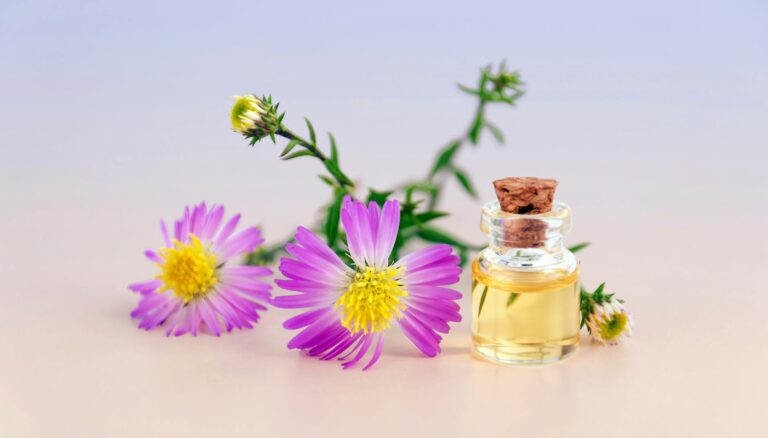 purple petal flowers with clear glass bottle with cork in white background