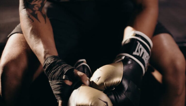 man in black tank top wearing blue and white boxing gloves
