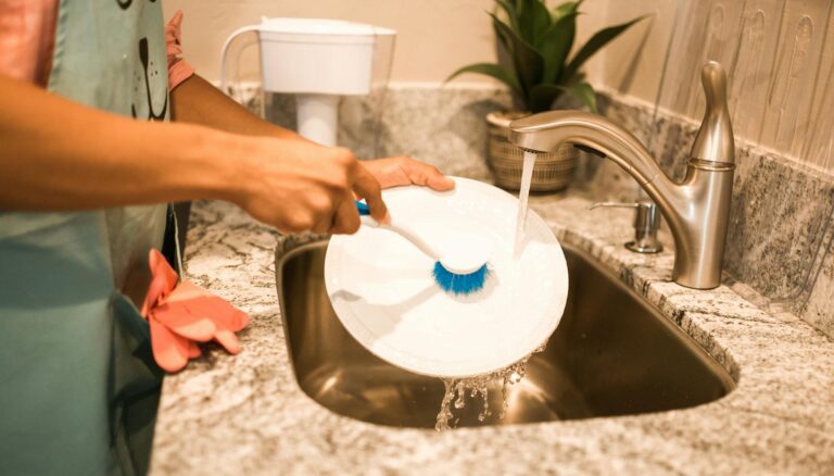photo of a person s hands washing a white plate