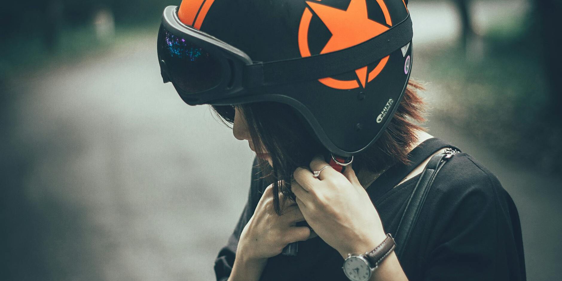 woman on black and orange half face helmet