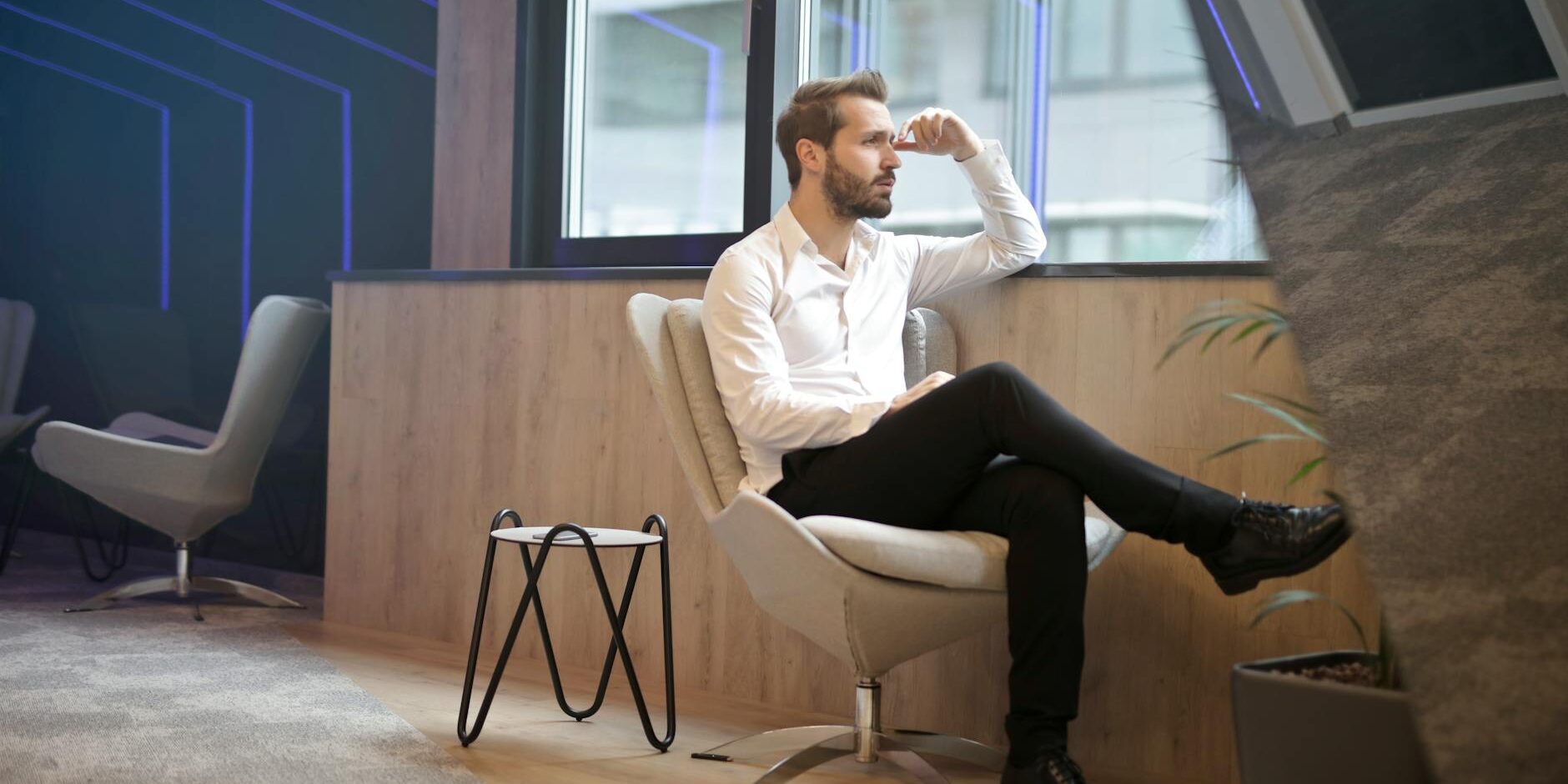 photo of a man sitting near the windoww
