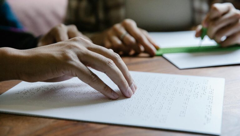 shallow focus photo of person using braille
