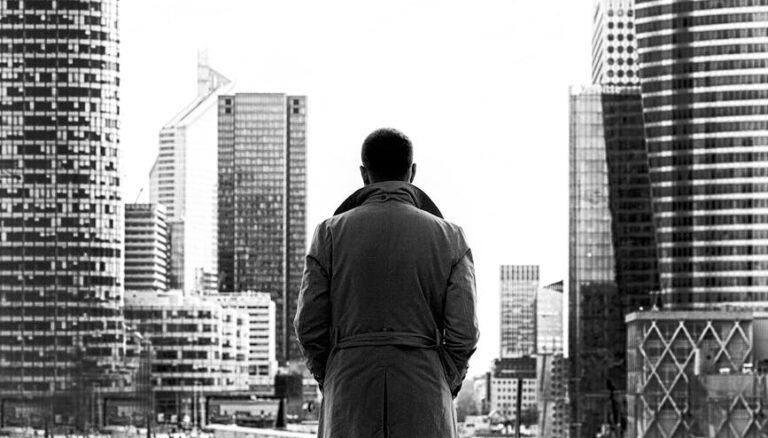 monochrome photo of man wearing trench coat