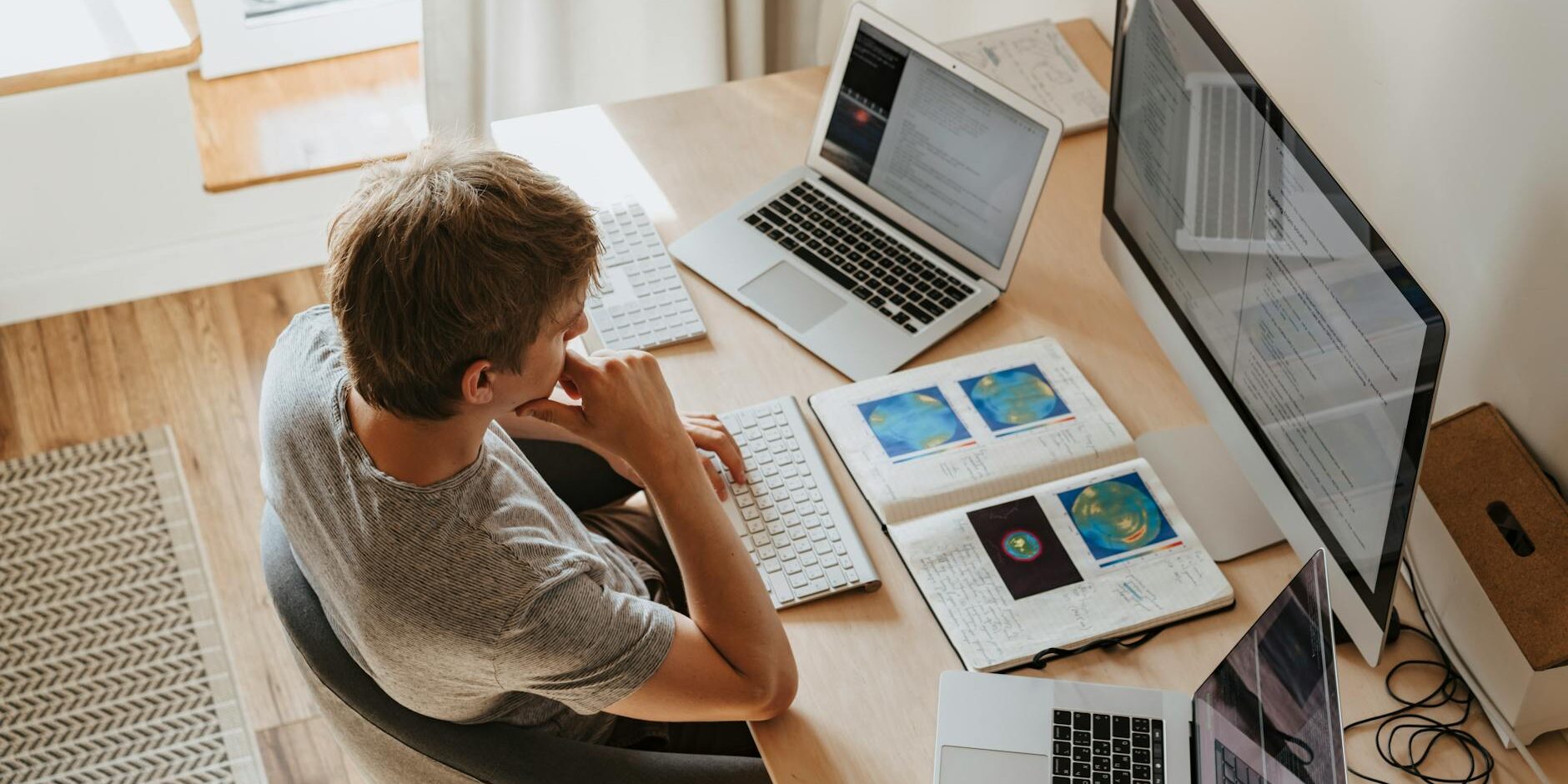 high angle shot of a boy sitting on grey chair while using his laptop computers
