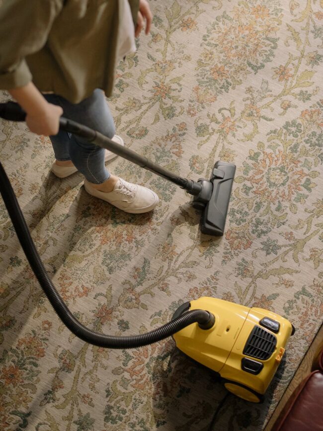person using a yellow and black vacuum cleaner