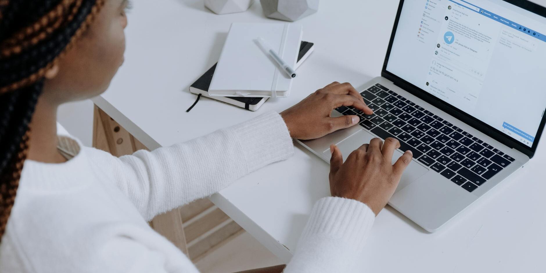 person in white long sleeve shirt using macbook air