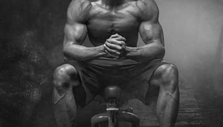 grayscale photo of man sitting on bench