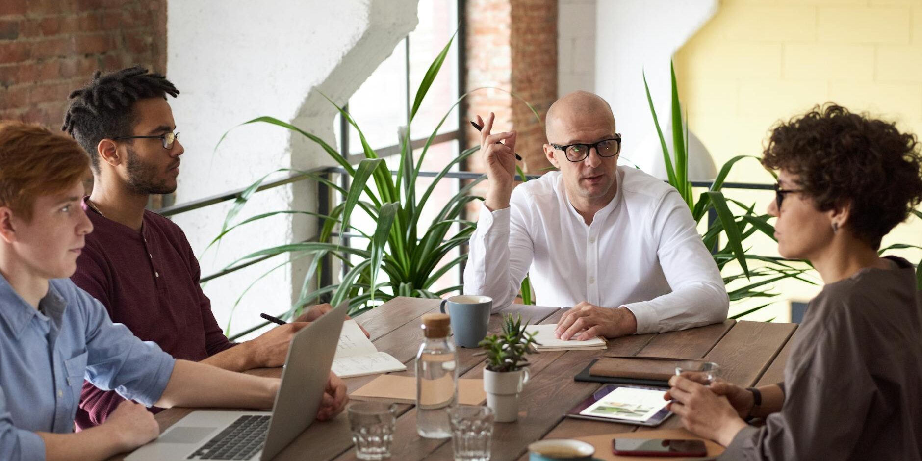 man wearing white long sleeved shirt holding black pen