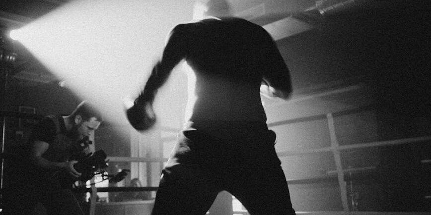 grayscale photo of man in white shirt and black pants