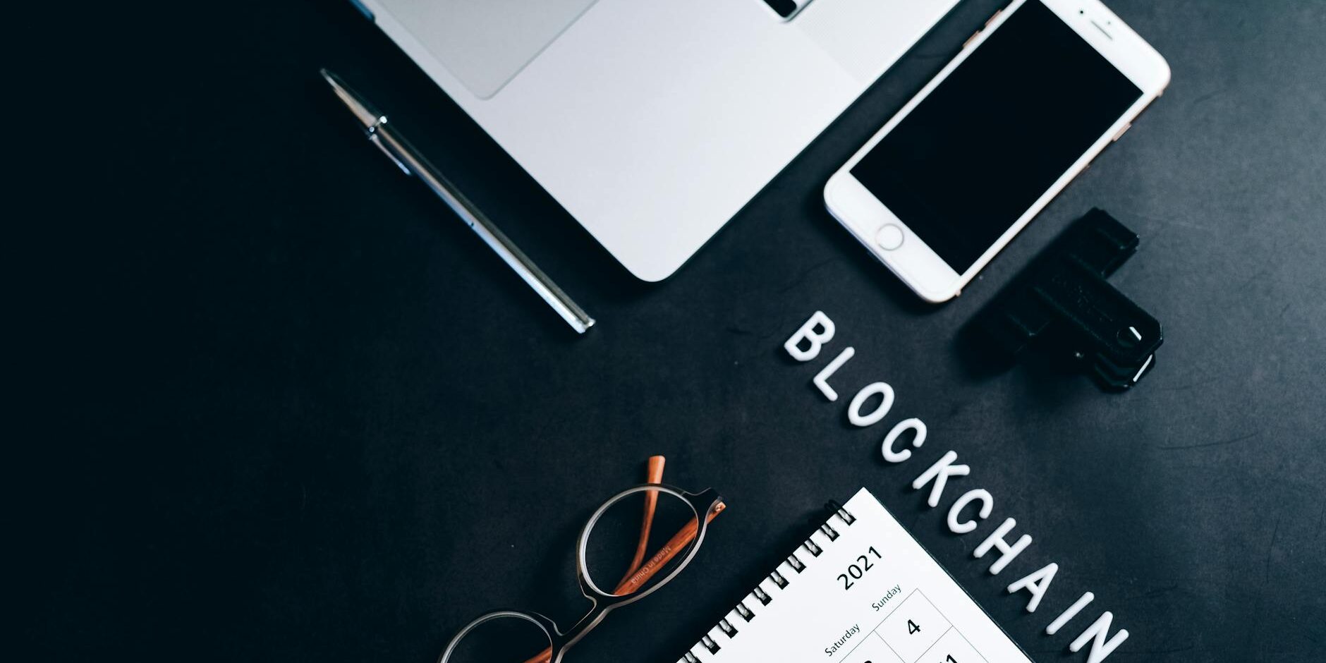 photo of eyeglasses near a silver pen