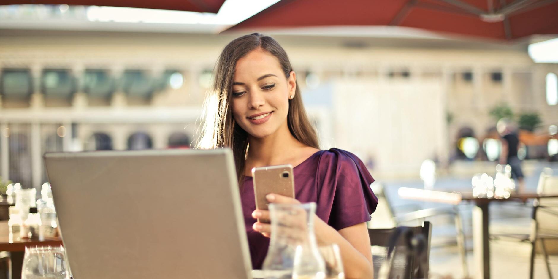 woman wearing purple shirt holding smartphone white sitting on chair