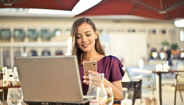 woman wearing purple shirt holding smartphone white sitting on chair