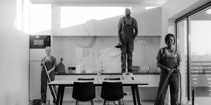 grayscale photo of people standing near table