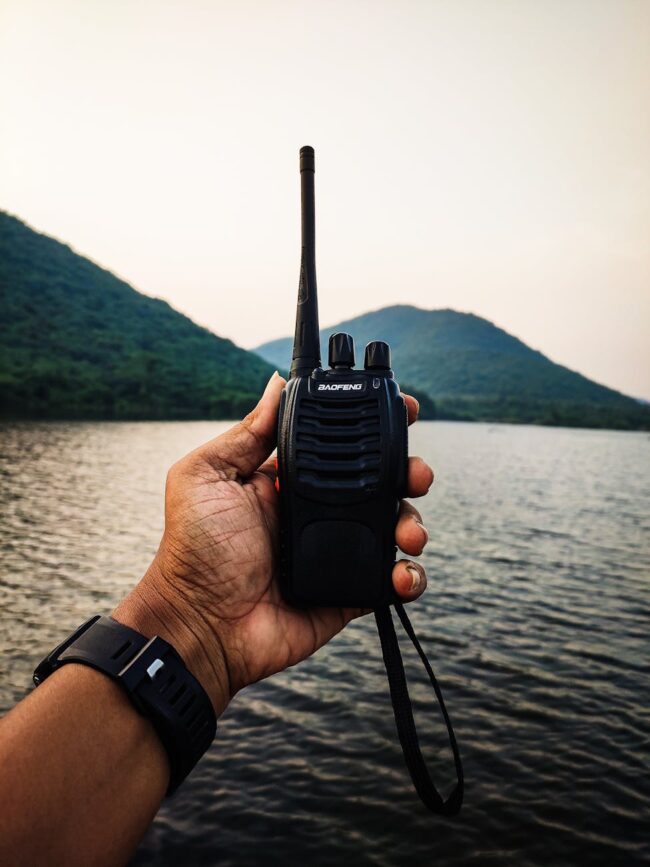 person holding a black two way radio