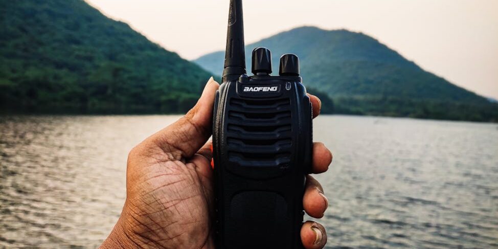 person holding a black two way radio