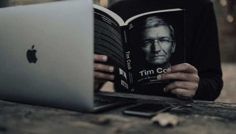 crop man with laptop reading book