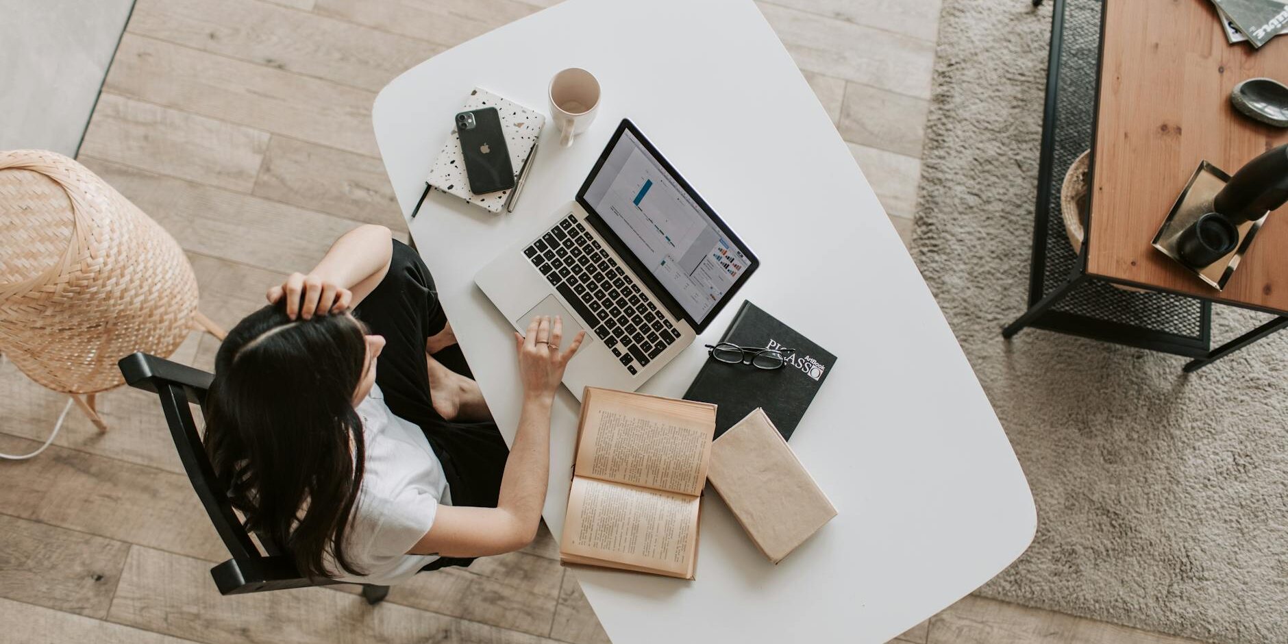 young lady using laptop at table in modern workspace