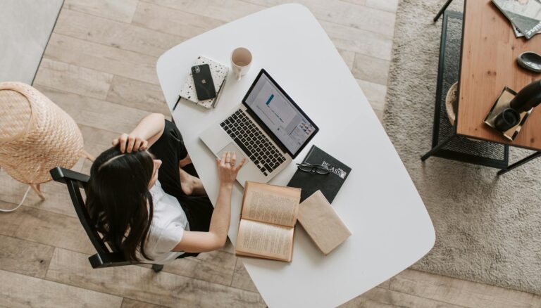 young lady using laptop at table in modern workspace