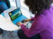 person using blue laptop sitting beside table
