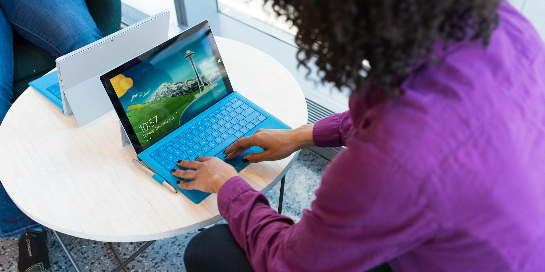 person using blue laptop sitting beside table