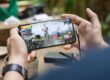 person holding a smartphone playing mobile game