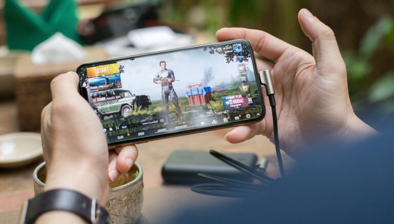 person holding a smartphone playing mobile game