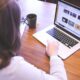woman swiping touchpad on macbook pro on table near smartphone and mug